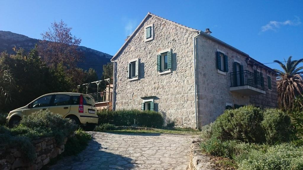 un coche aparcado frente a una casa de piedra en House Pod Humom en Jelsa