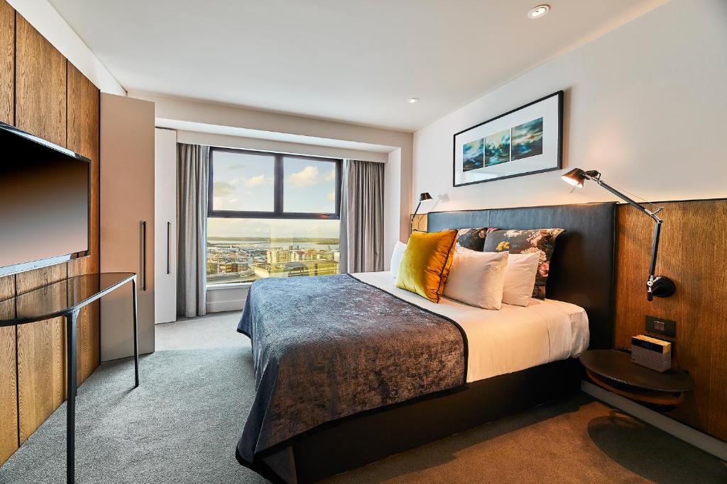 pokój hotelowy z łóżkiem i dużym oknem w obiekcie The Grand by SkyCity w Auckland