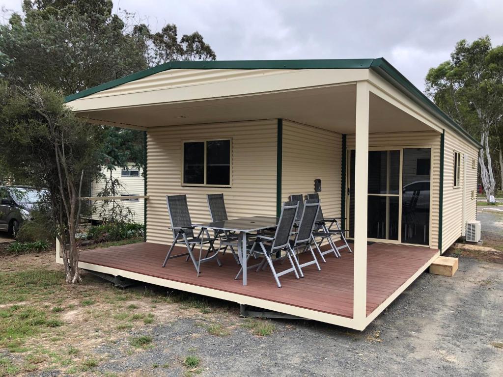 ein kleines Haus mit einem Tisch und Stühlen auf einer Terrasse in der Unterkunft G'Day Parks Ararat in Ararat