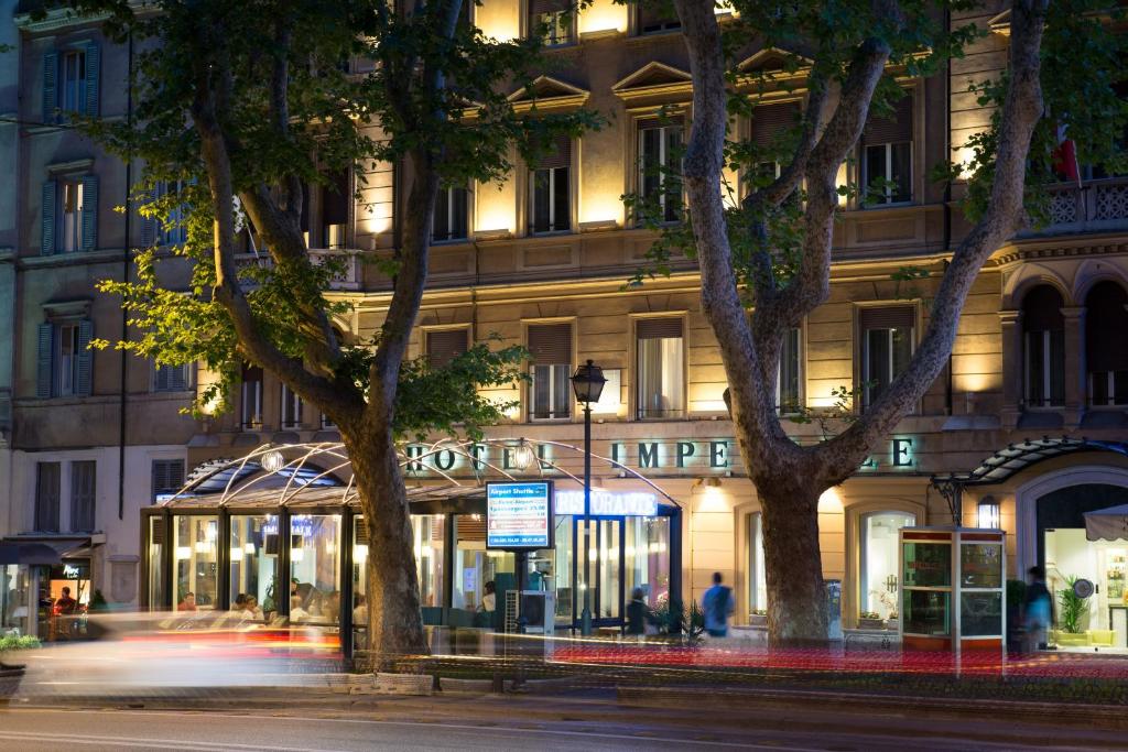 a building on a street with trees in front of it at Hotel Imperiale by OMNIA hotels in Rome