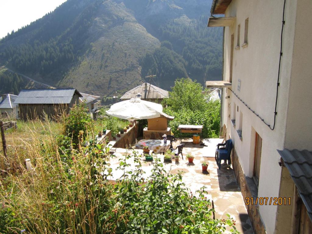 Aussicht von einem Gebäude mit einem Regenschirm und einem Berg in der Unterkunft Kristal Guest House in Trigrad