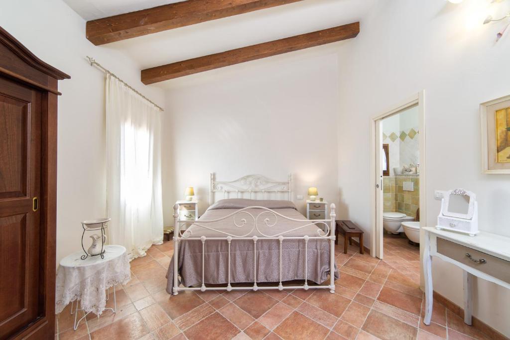 a white bedroom with a bed and a bathroom at Poggio ai Legni in Certaldo