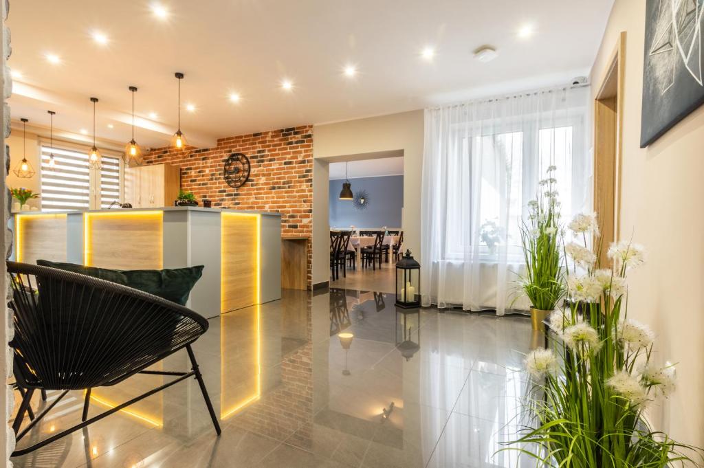 Una sala de estar con una mesa y sillas y una pared de ladrillos. en Astoria Fly Modlin Airport, en Pomiechówek