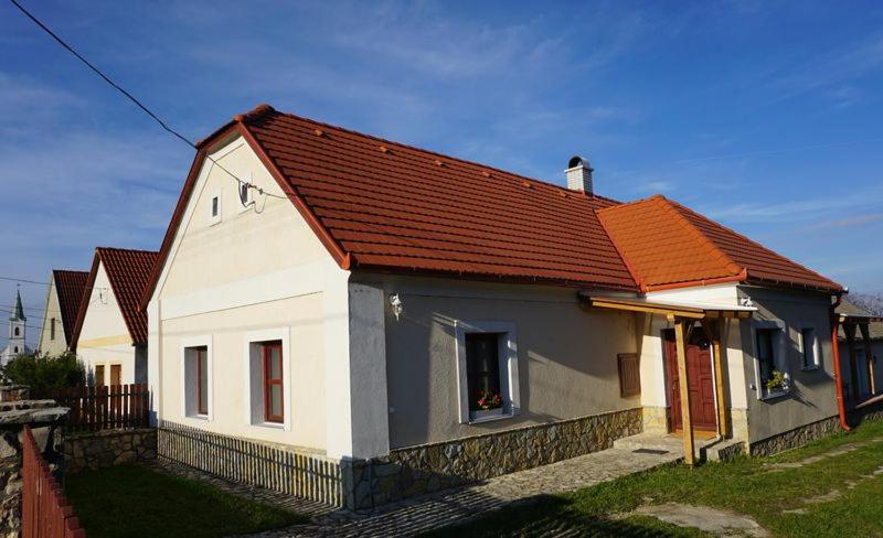 una pequeña casa blanca con techo naranja en Sváb Ház, en Veszprémfajsz
