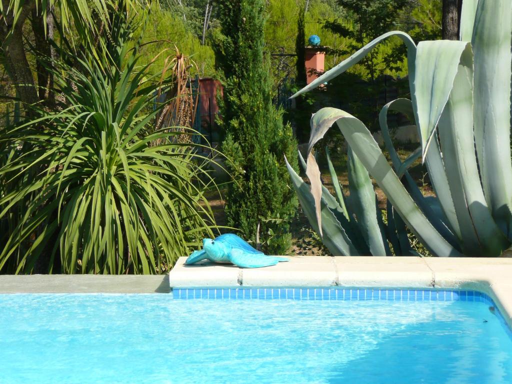 uma piscina com uma toalha azul sentada ao lado em Les Pitounus em Les Arcs sur Argens