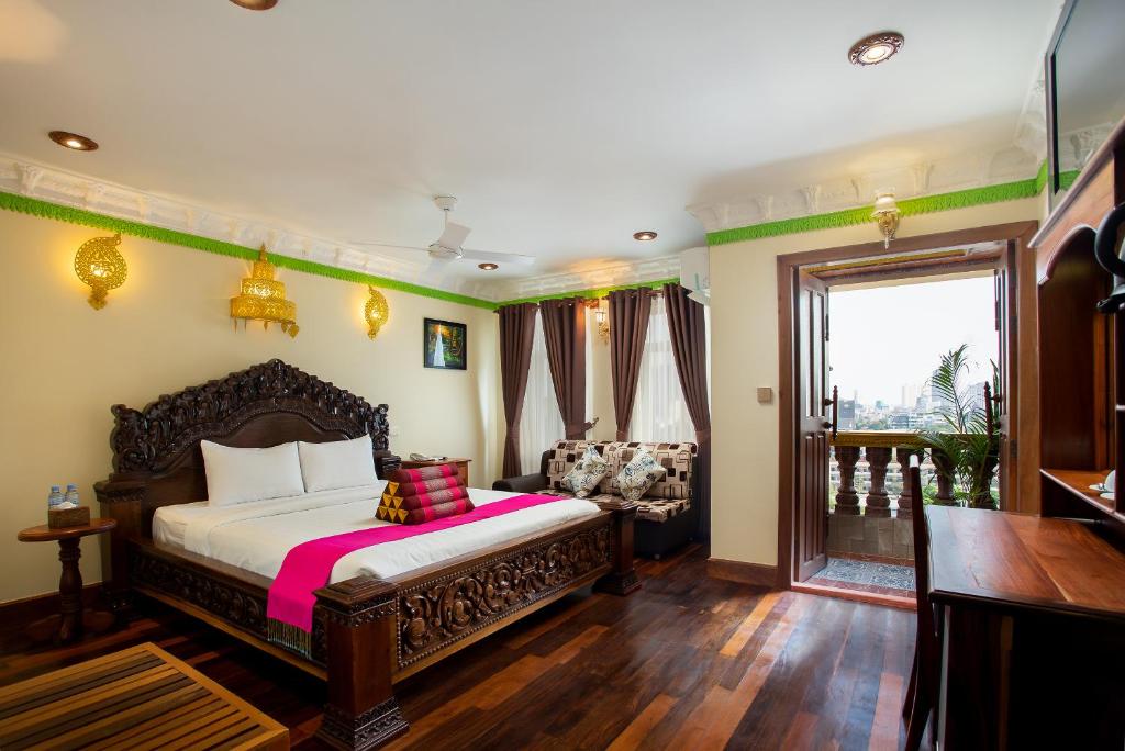 a bedroom with a bed and a living room at Okay Palace Hotel in Phnom Penh