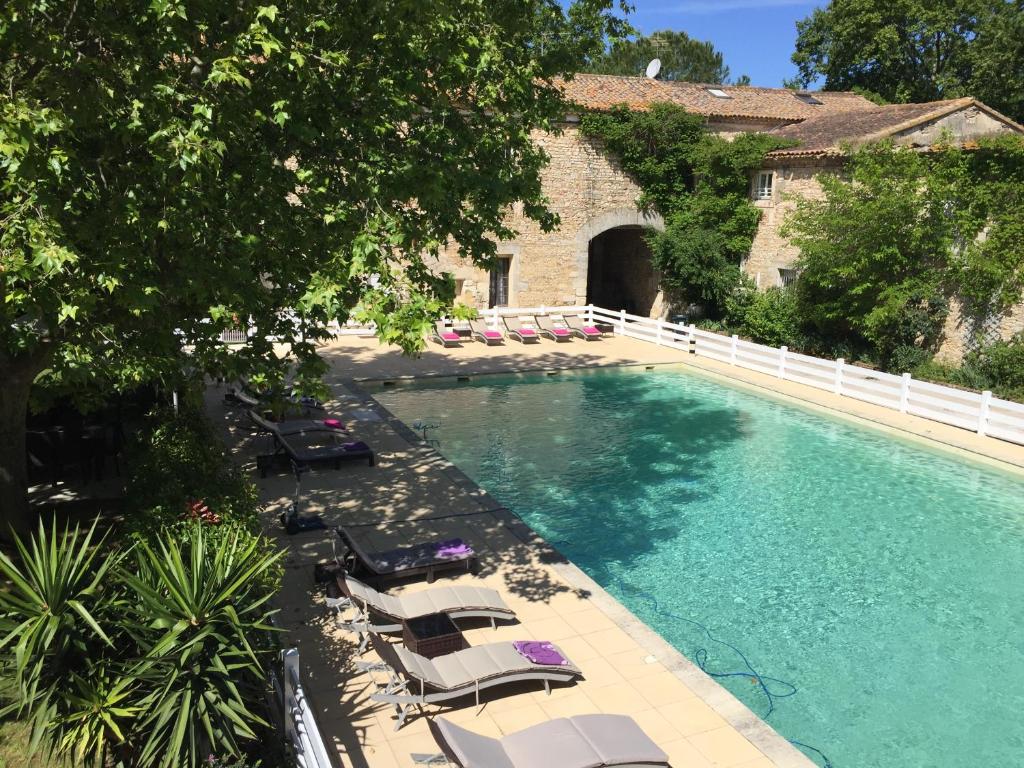 - une vue sur la piscine et ses chaises longues dans l'établissement Hotel Mas De Galoffre, à Nîmes