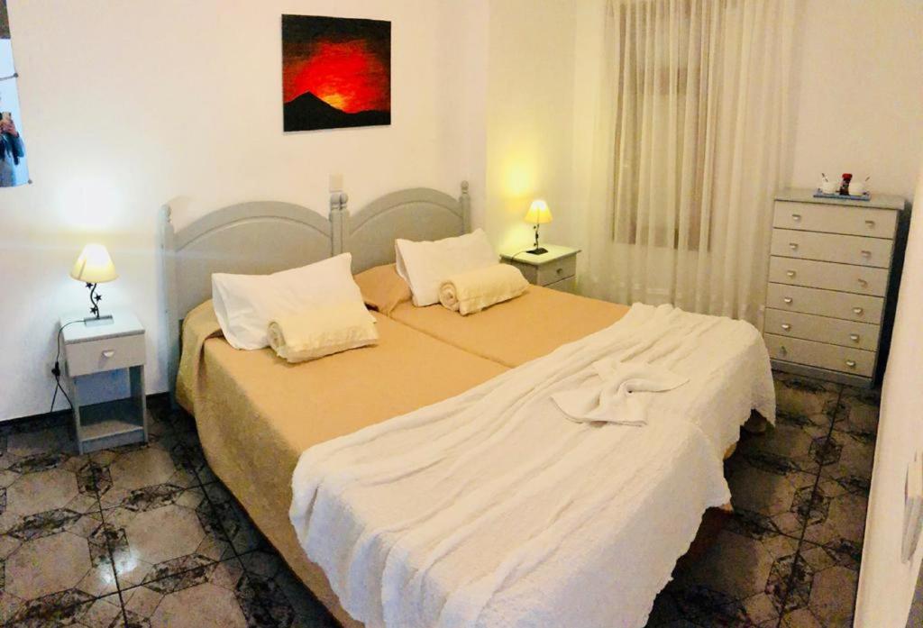 ein Schlafzimmer mit einem großen Bett mit zwei Kissen in der Unterkunft Enjoy the sea and pool in Playa de las Americas in Playa de las Americas