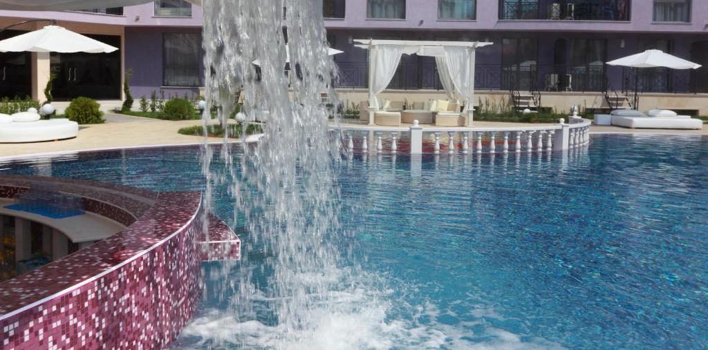a fountain in the middle of a swimming pool at Hotel Rainbow 3 Resort Club in Sunny Beach