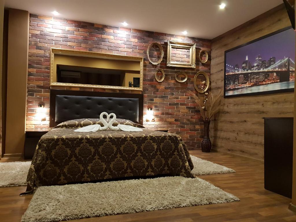 una camera con un grande letto e un muro di mattoni di Guest House Amore a Sandanski
