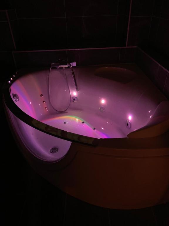 eine lila Badewanne mit Licht in einem dunklen Raum in der Unterkunft Le Paradis Perdu in Rouen