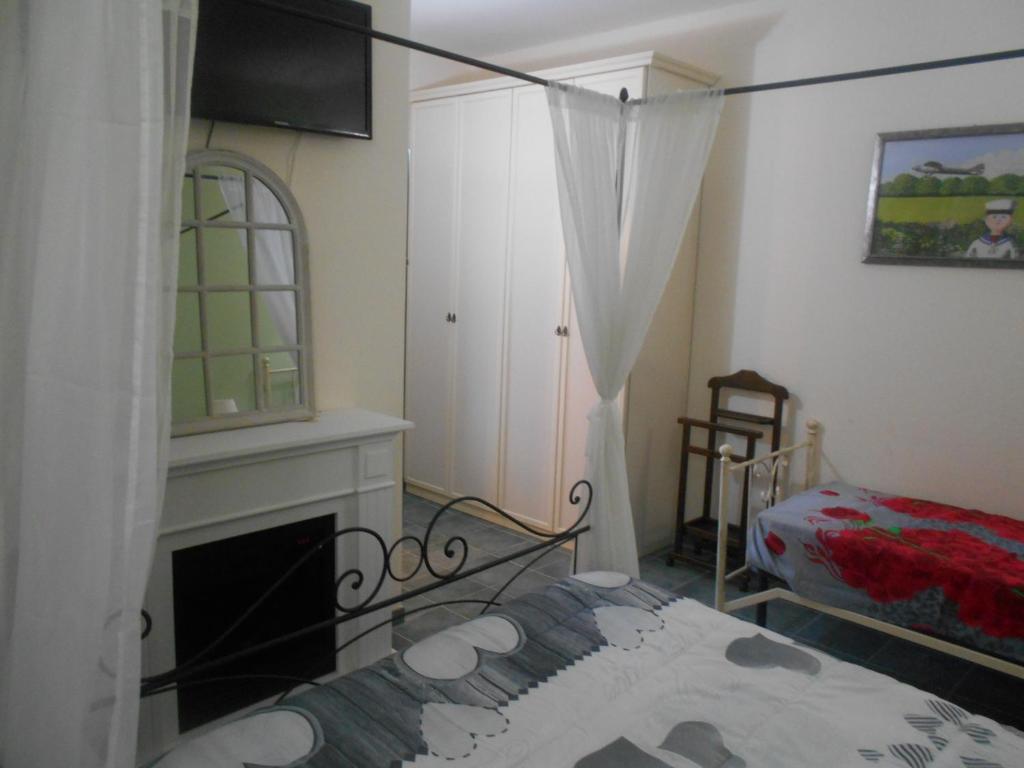 Relais"LA CAPPUCCINA" Rooms&Apartments في أسيسي: غرفة فيها موقد وسرير وتلفزيون