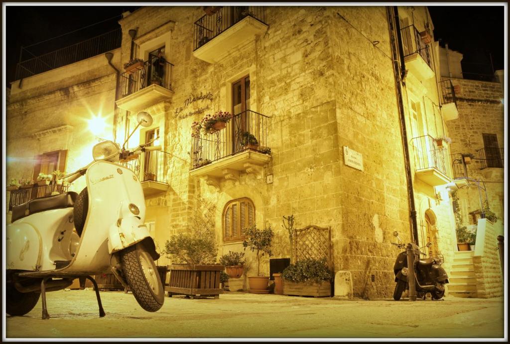 una moto blanca estacionada frente a un edificio en B&B La Muraglia en Bari