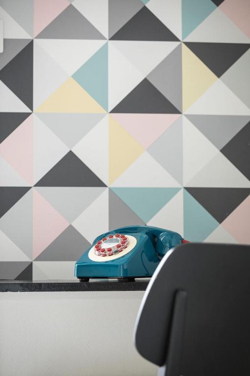 un téléphone bleu assis sur une étagère à côté d&#39;un mur dans l&#39;établissement Hotel de Paris, à La Rochelle