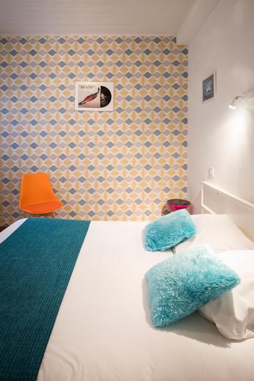 - une chambre avec un lit et une chaise orange dans l&#39;établissement Hotel de Paris, à La Rochelle