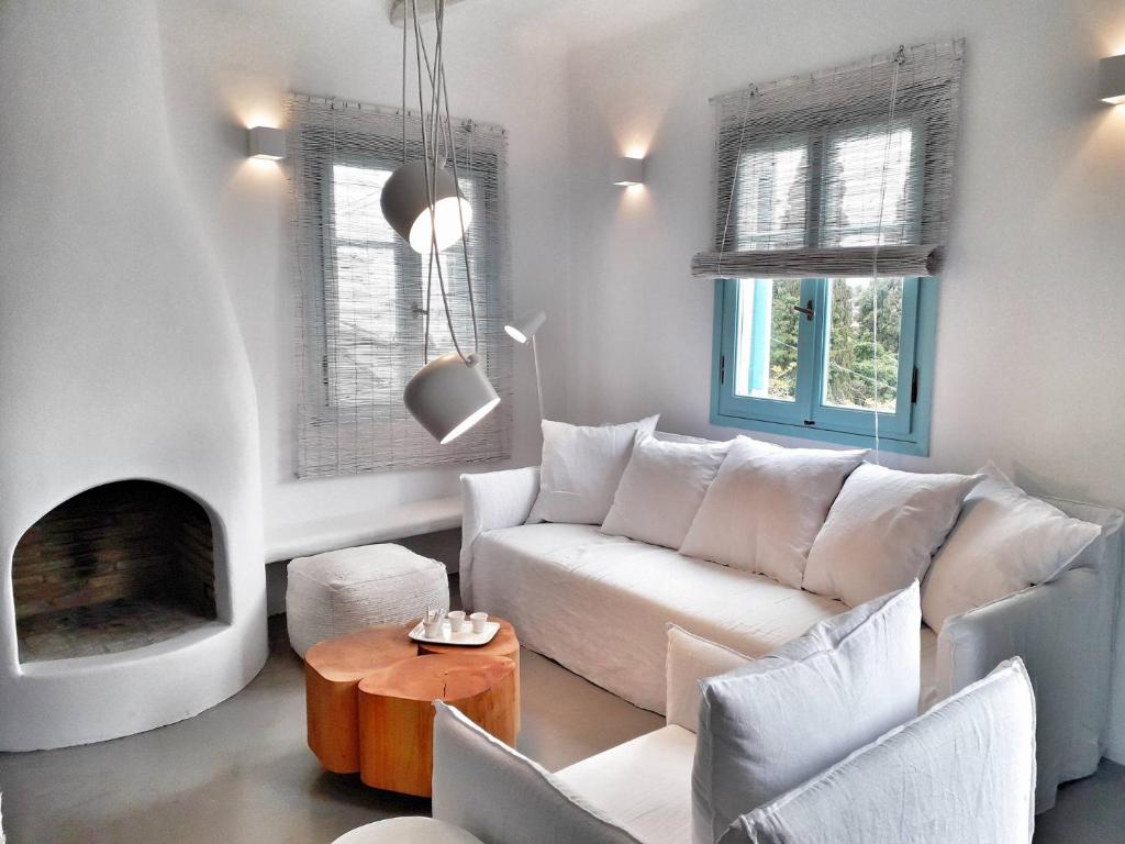 a living room with a white couch and a fireplace at Villa Arion in Batsi