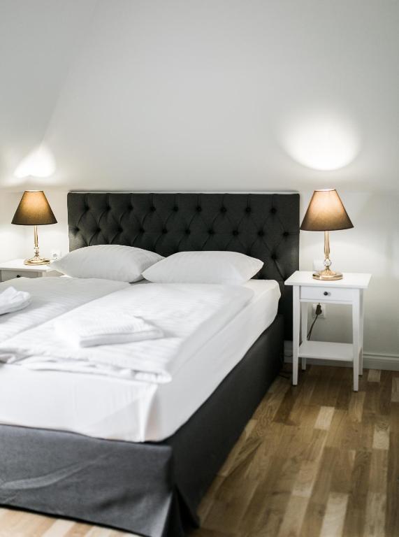 a bedroom with a large bed and two lamps on tables at Hotel Usadba in Kaliningrad