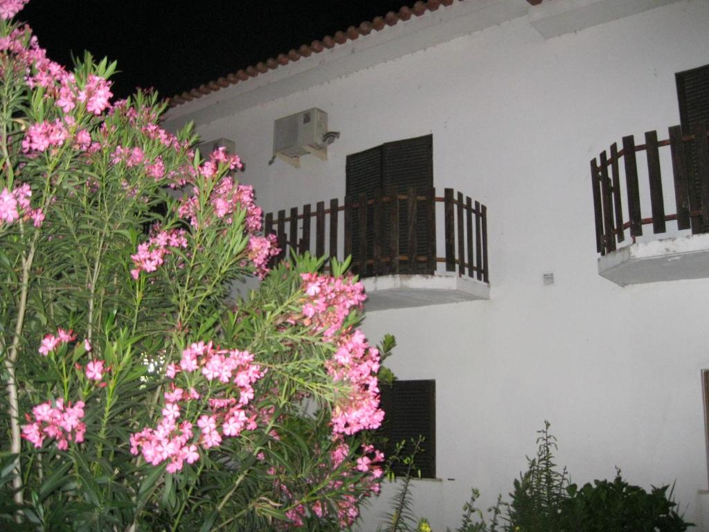un edificio blanco con flores rosas y balcones en Casa Morgado en Almeida