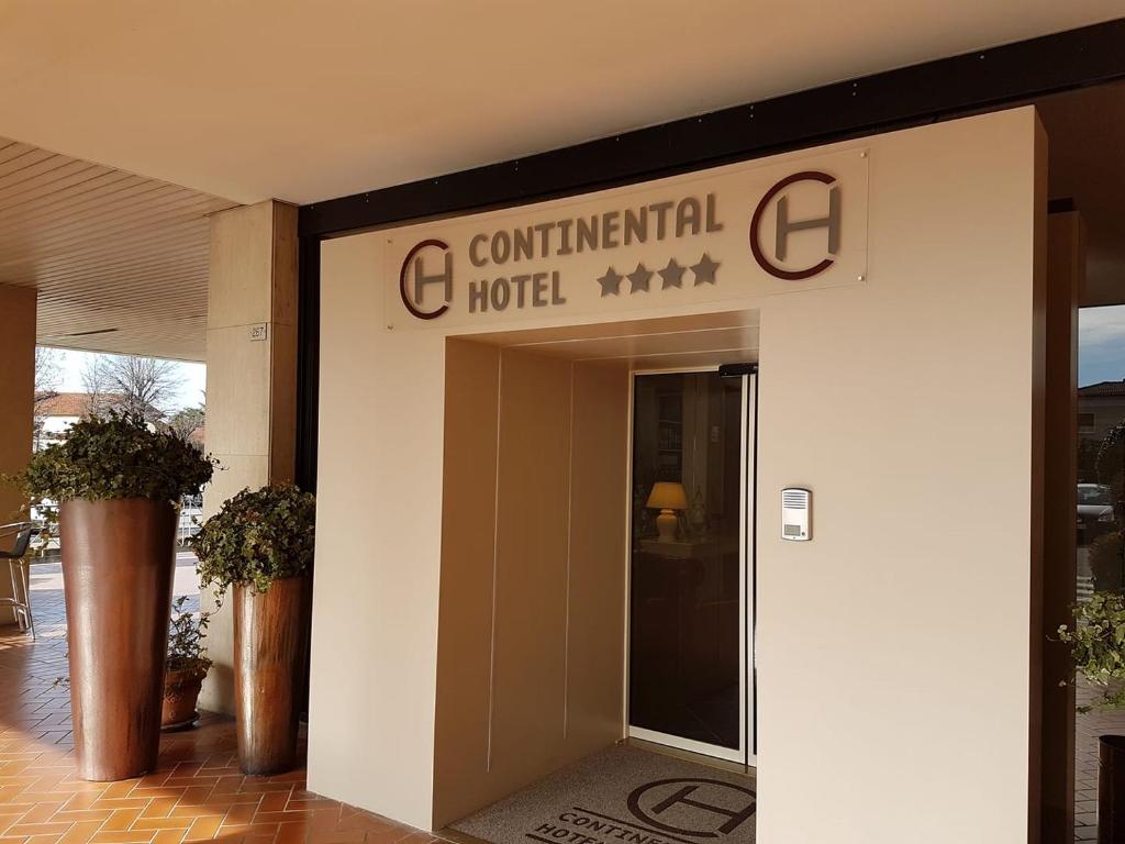 une entrée à un hôtel avec un panneau sur celui-ci dans l'établissement Hotel Continental Brescia, à Roncadelle