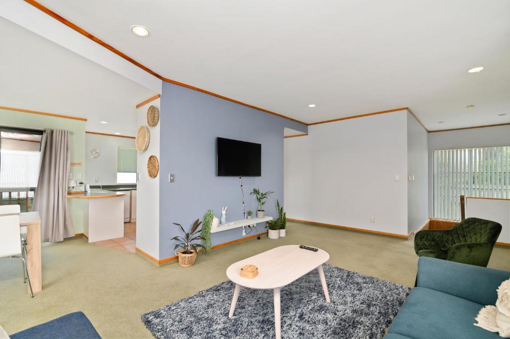 a living room with a couch and a table at Red Door holiday house in Rotorua