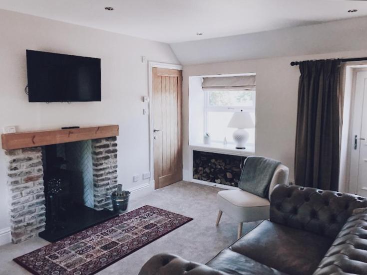 a living room with a couch and a fireplace at No.03 Cottage in Strathkinness