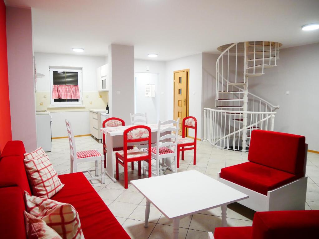 uma sala de estar com cadeiras vermelhas e uma mesa em Niewinne domki - Burgundia em Żywiec