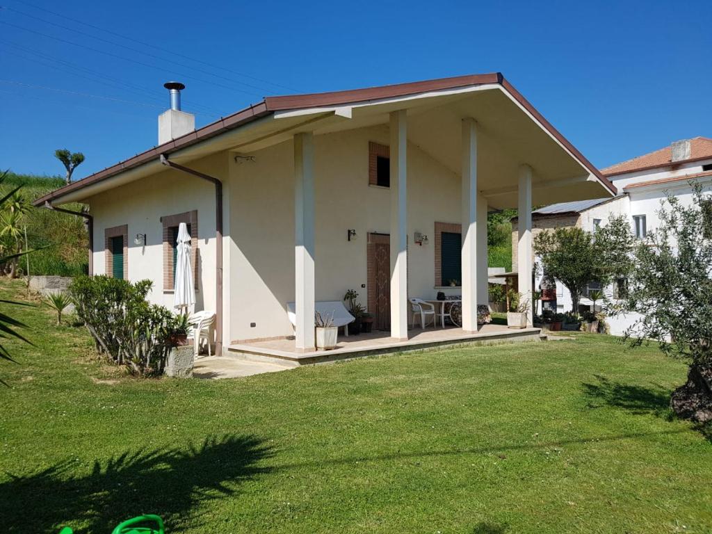 a white house with a lawn in front of it at Villetta in collina a due passi dal mare in Colonnella