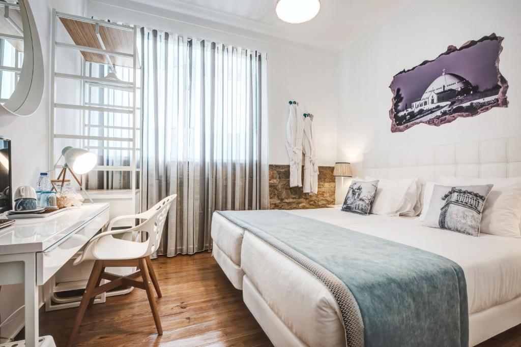 um quarto branco com uma cama e uma secretária em Loulé Coreto Guesthouse em Loulé