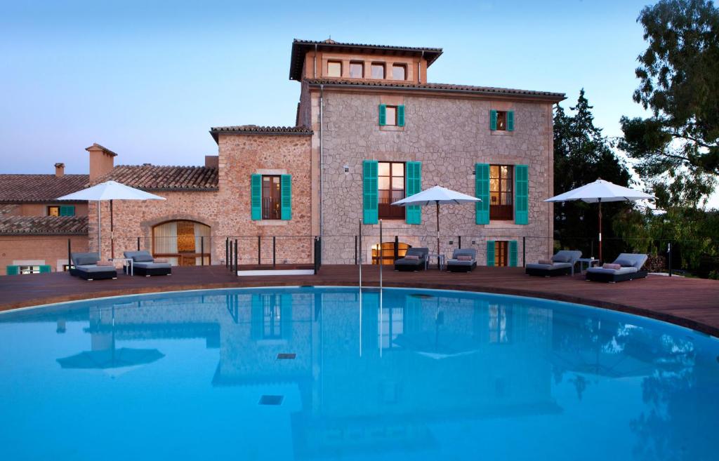 a villa with a swimming pool in front of a building at Sa Cabana Hotel & Spa - Adults Only in Consell