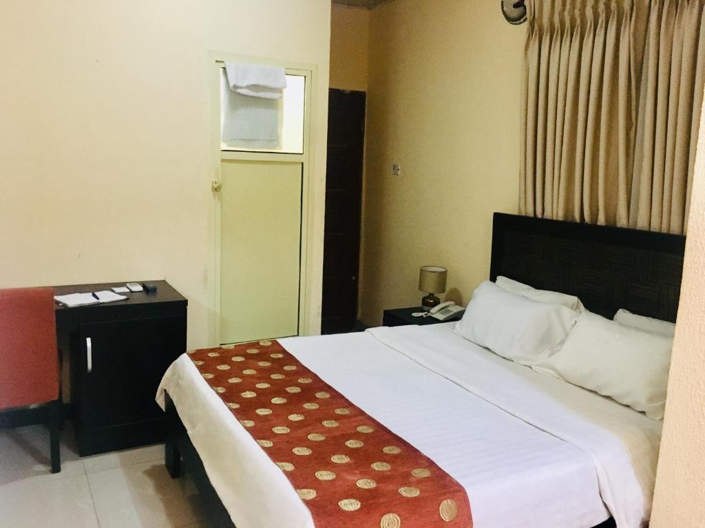 a hotel room with a large bed and a window at Light House Hotel in Lekki