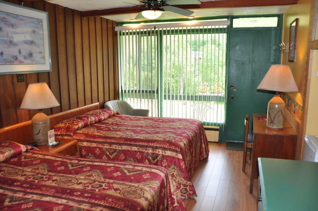 a hotel room with two beds and a window at Le Boisé du Lac in Mont-Tremblant