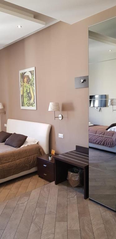 1 dormitorio con 2 camas, escritorio y espejo en Mia Suites, en Roma