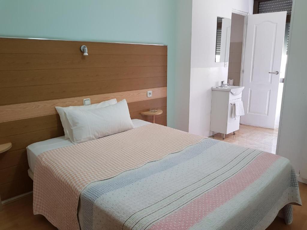 a bedroom with a large bed with a wooden headboard at Hostal Lima in Valladolid