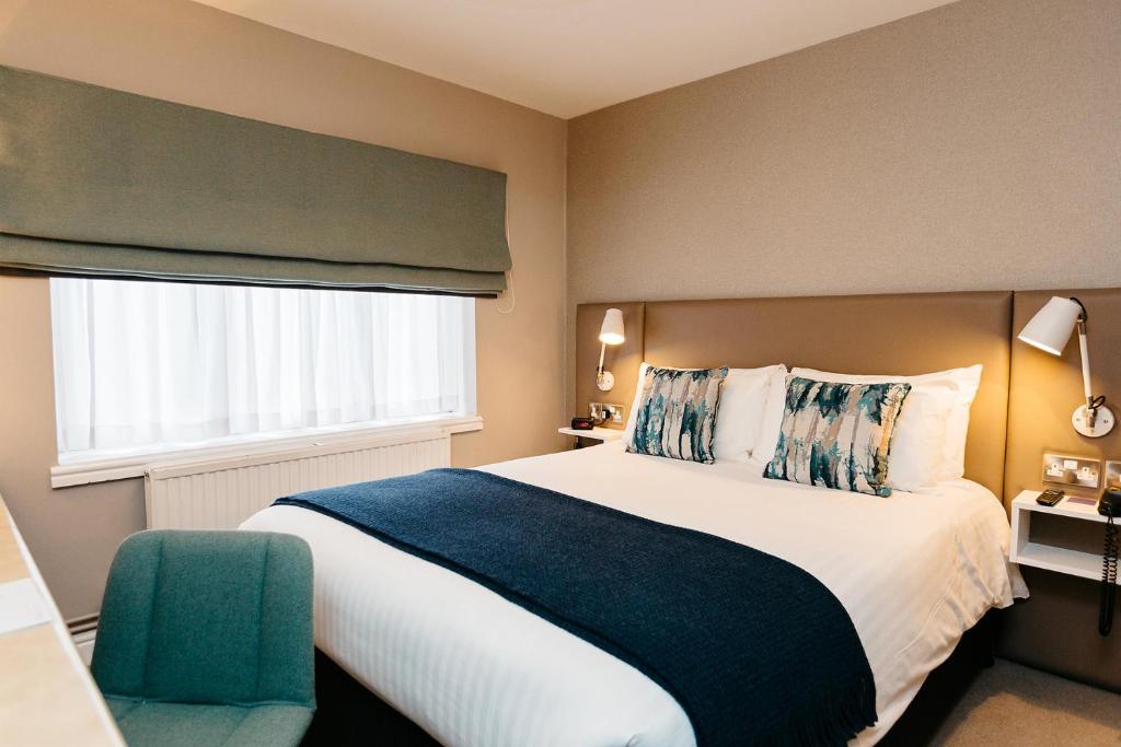 1 dormitorio con 1 cama grande y 1 silla verde en Peter Scott House Birmingham en Birmingham