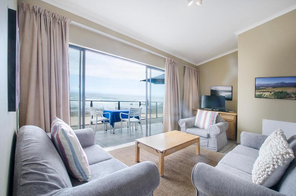 赫爾羅德灣的住宿－Herolds Bay Accommodation - Hiers Ons Weer Upstairs，带沙发和椅子的客厅以及大窗户。