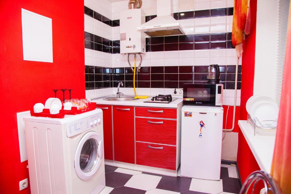 a red and white kitchen with a washing machine at 2Rooms Semi-luxury Apartment on Pochtovaya 167-A Street in Zaporozhye
