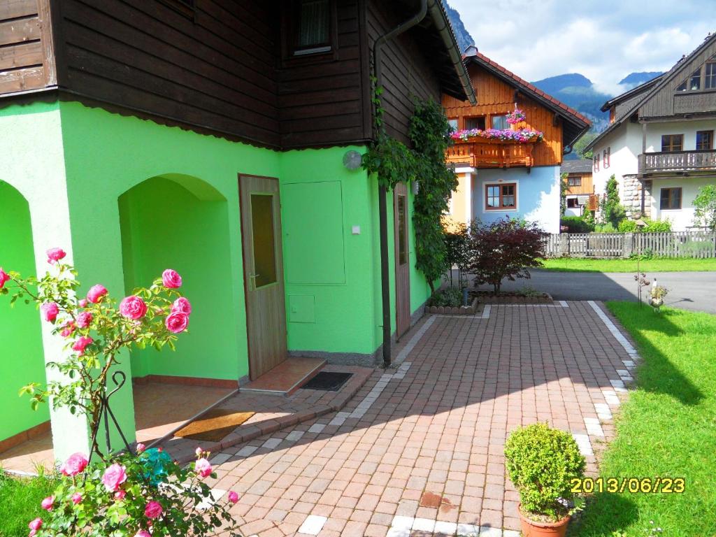 ein grünes und weißes Haus mit einer steinernen Einfahrt in der Unterkunft Apartment Silvia Cijan in Hallstatt