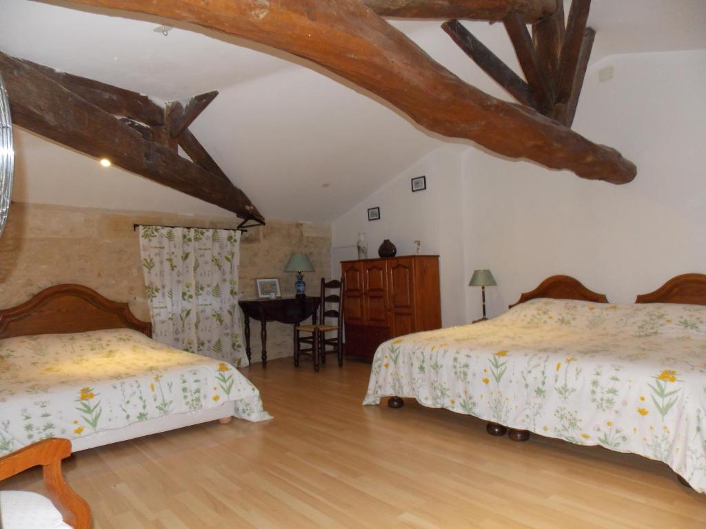 1 dormitorio con 2 camas y mesa. en Gîte l'Antre Vous en Saint-Philippe-dʼAiguille