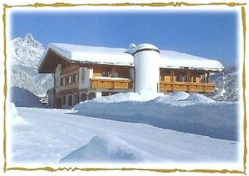 ein schneebedecktes Gebäude mit einem Stapel Schnee in der Unterkunft Ferienwohnungen Hinterholzer in Sankt Jakob in Haus