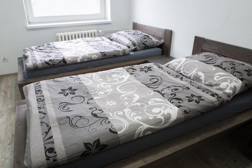 dos camas sentadas una al lado de la otra en un dormitorio en Kopačka en Topoľčany