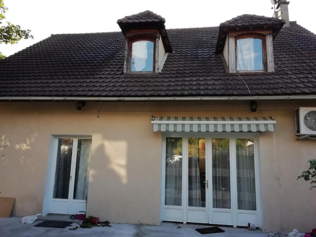 オルネー・スー・ボアにあるChambres d'Hôtes Chez Marilouの白い扉と茶色の屋根の家