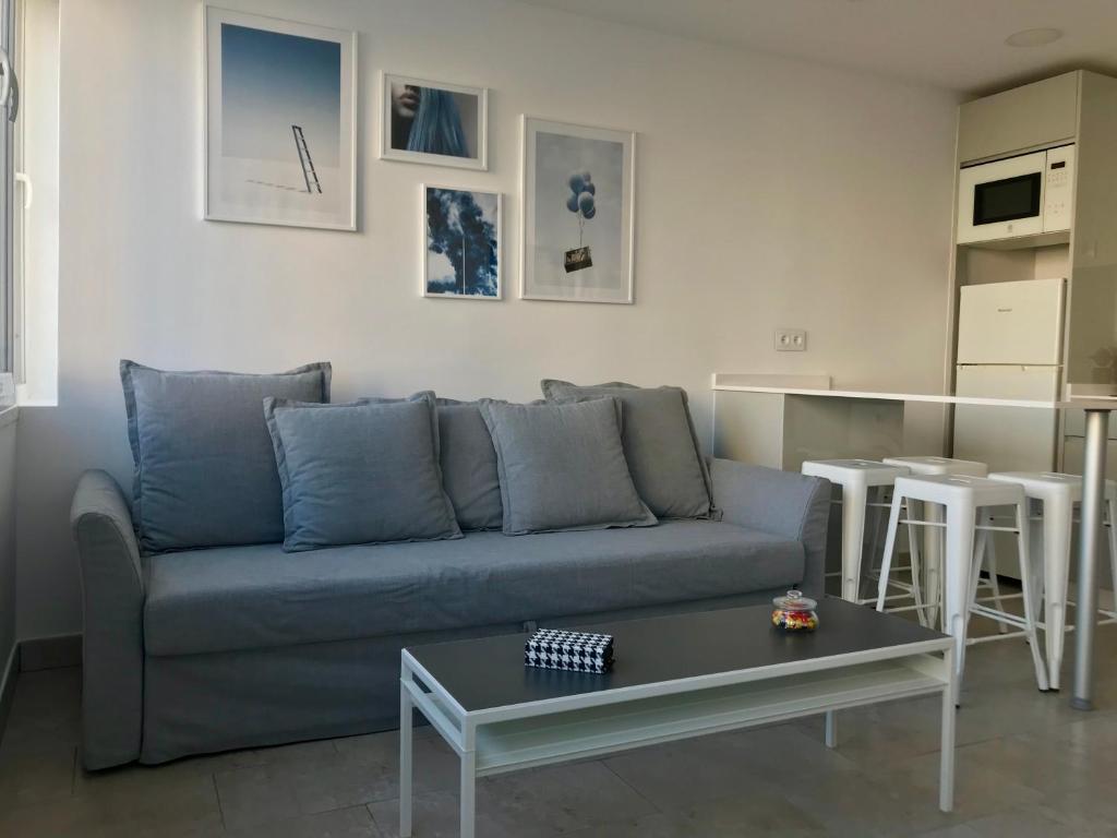 uma sala de estar com um sofá azul e uma mesa em Apartamento Sol y Mar em Torremolinos