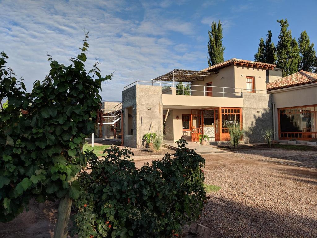 a house with a yard with bushes in front of it at Posada Cavieres Wine Farm in Maipú