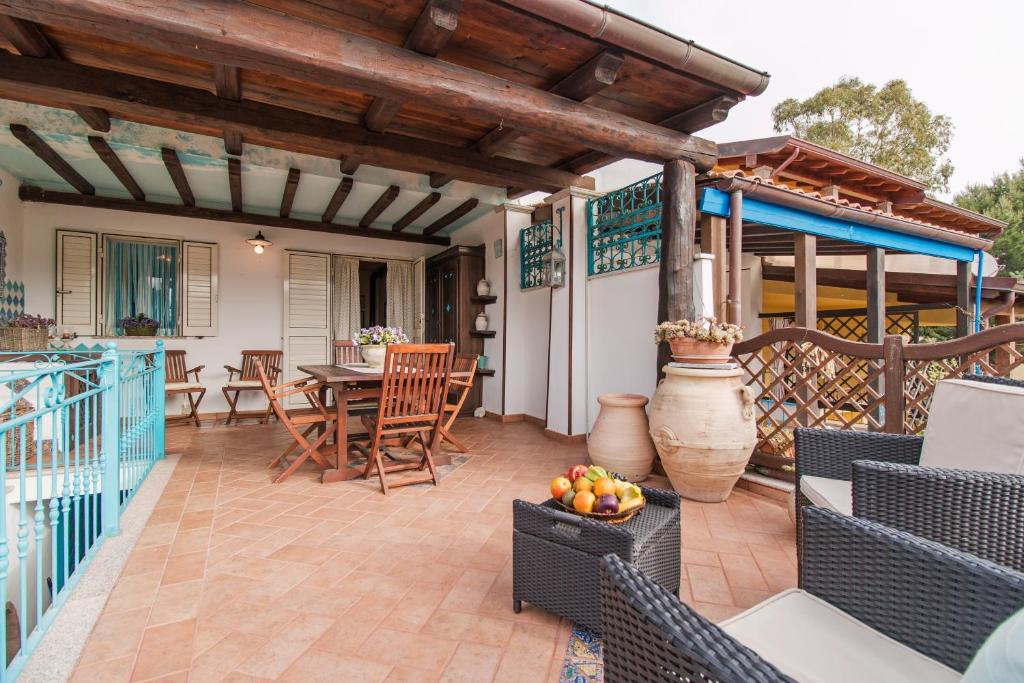 a patio with a table and chairs on a deck at Casa Lentischio in Cala Gonone