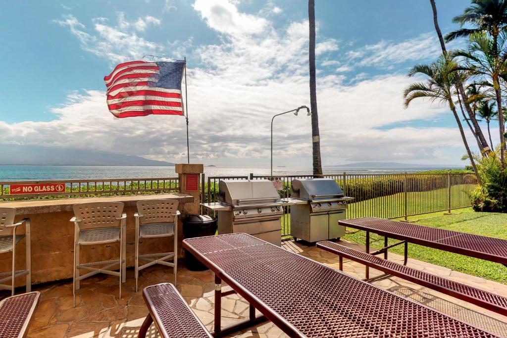 einen Grill und Picknicktische mit amerikanischer Flagge in der Unterkunft Island Sands Resort in Wailuku