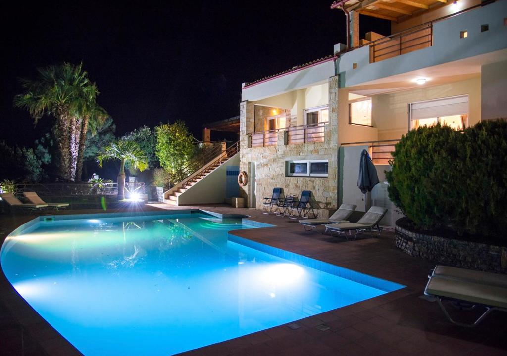 a swimming pool in front of a house at night at Villa Irida in Agios Nikolaos