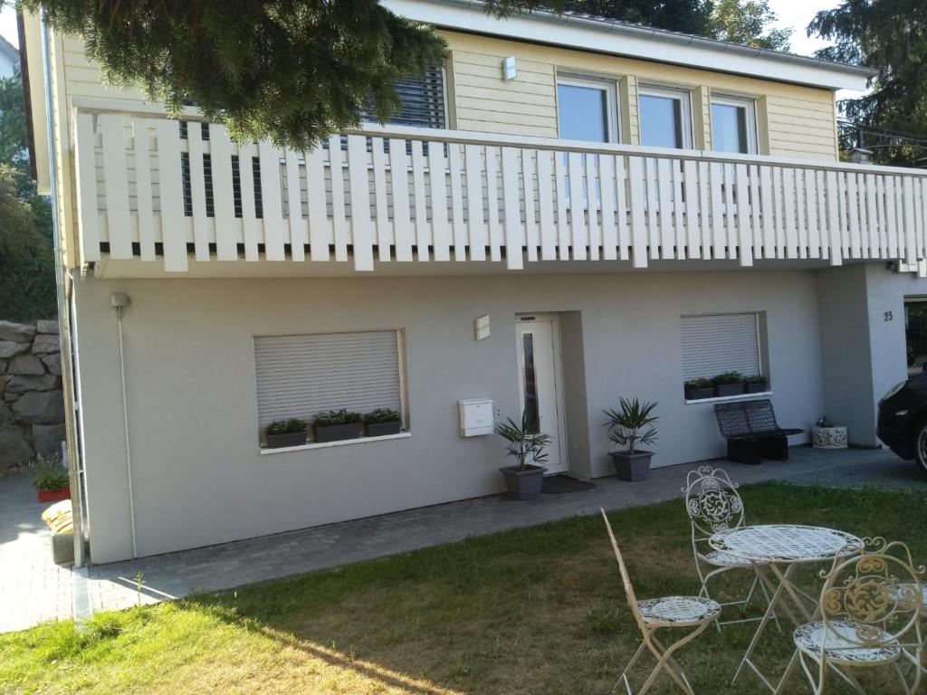 a house with a balcony and two chairs at Familiehuis Dolve 2 in Hartheim