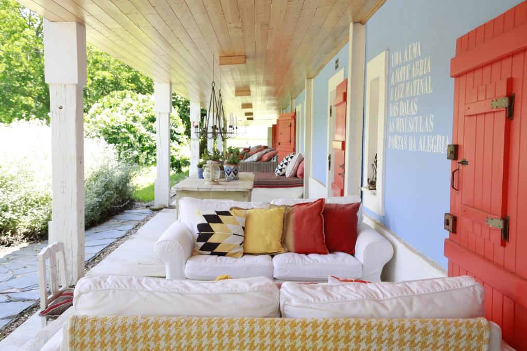 a porch with a white couch on a patio at Herdade da Matinha Country House & Restaurant in Cercal