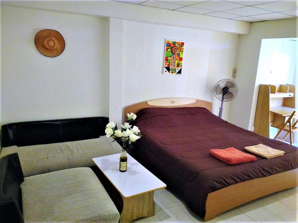 - une petite chambre avec un lit et un canapé dans l'établissement Hin Nam Sai Suay Condominium, à Hua Hin