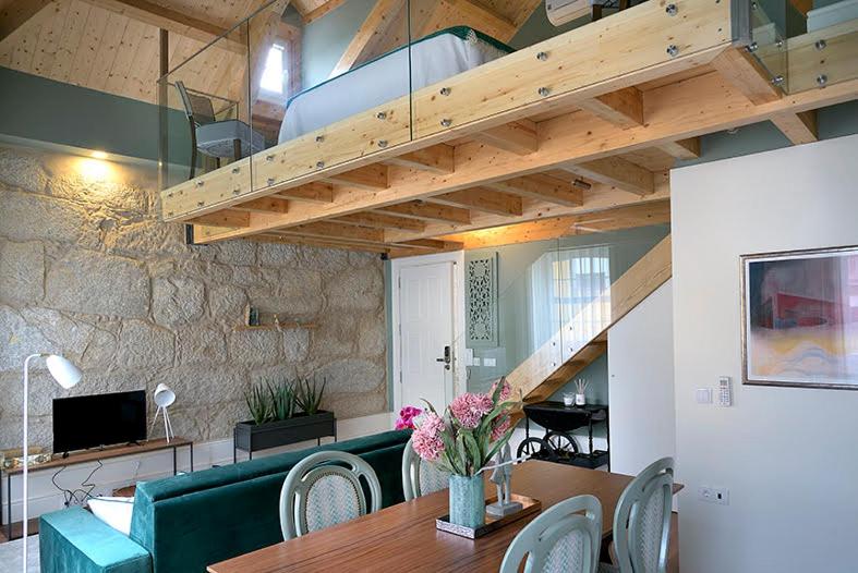 a living room with a couch and a table and a staircase at Mayor's Apartments in Porto